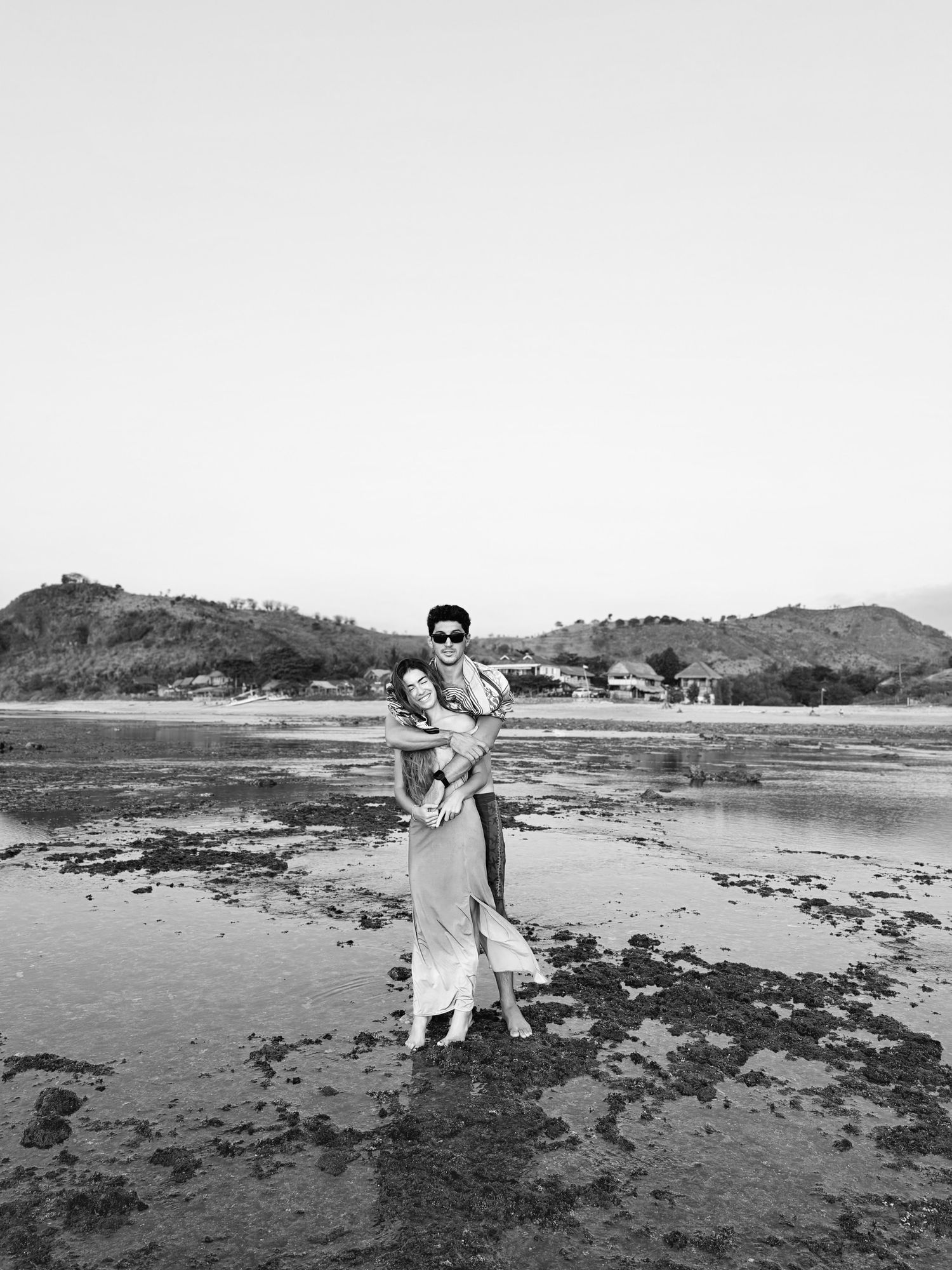 María y Álvaro abrazados en la orilla de la playa