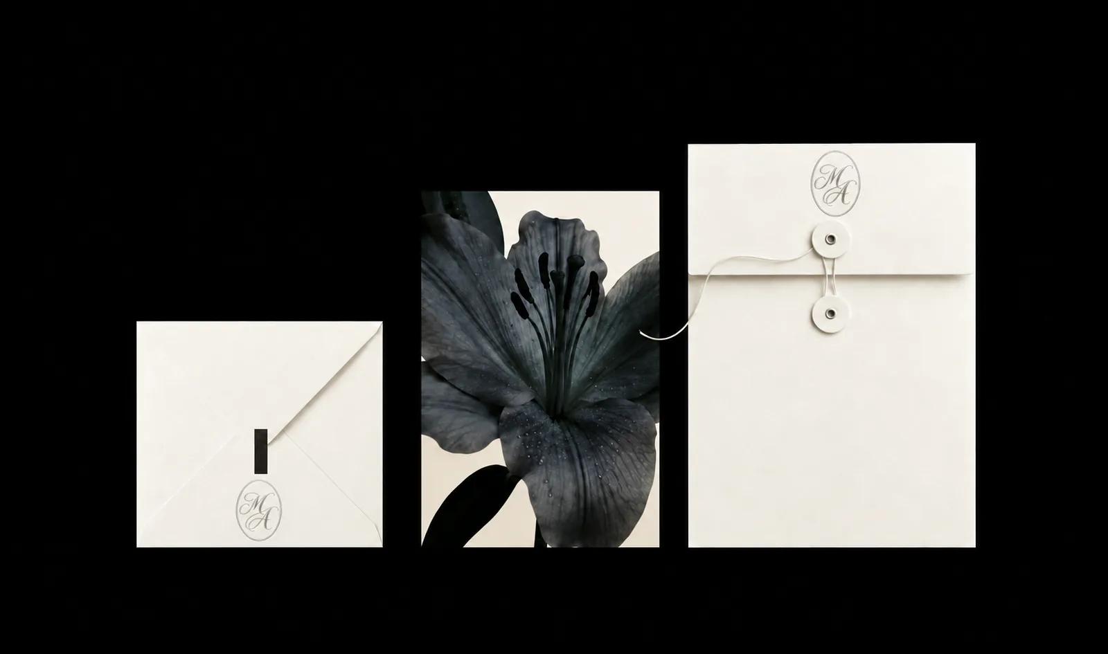 Dos sobres de papel marfil con el monograma ovalado M y A y una fotografía de una flor oscura en el centro, sobre fondo negro